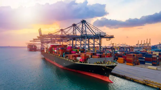 A freight container being loaded onto a cargo ship, symbolizing the importance of efficient freight logistics in facilitating international trade and supply chain operations.