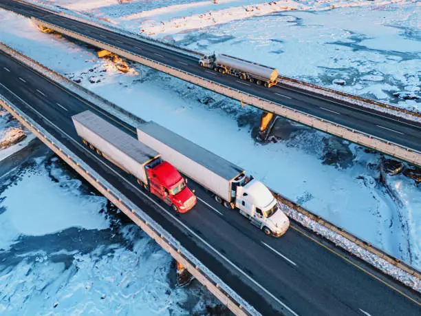 A fleet of trucks on a highway, symbolizing the role of trucking companies in road transportation and the significance of selecting reliable carriers to ensure timely delivery of goods.